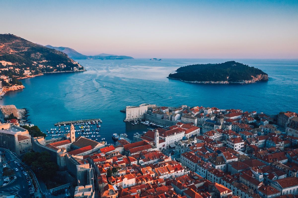 Aerial view of Dubrovnik. A cityscape in the foreground with the sea and an island in the background.