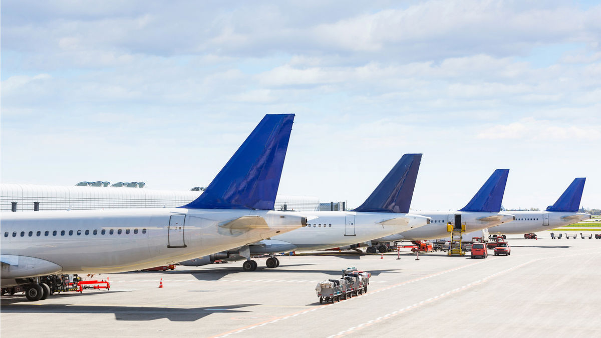 4 planes on tarmac with tails showing