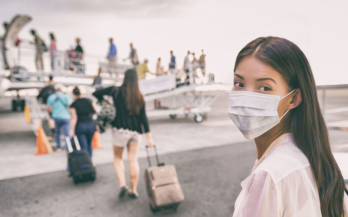 Woman wearing a mask boards a plane