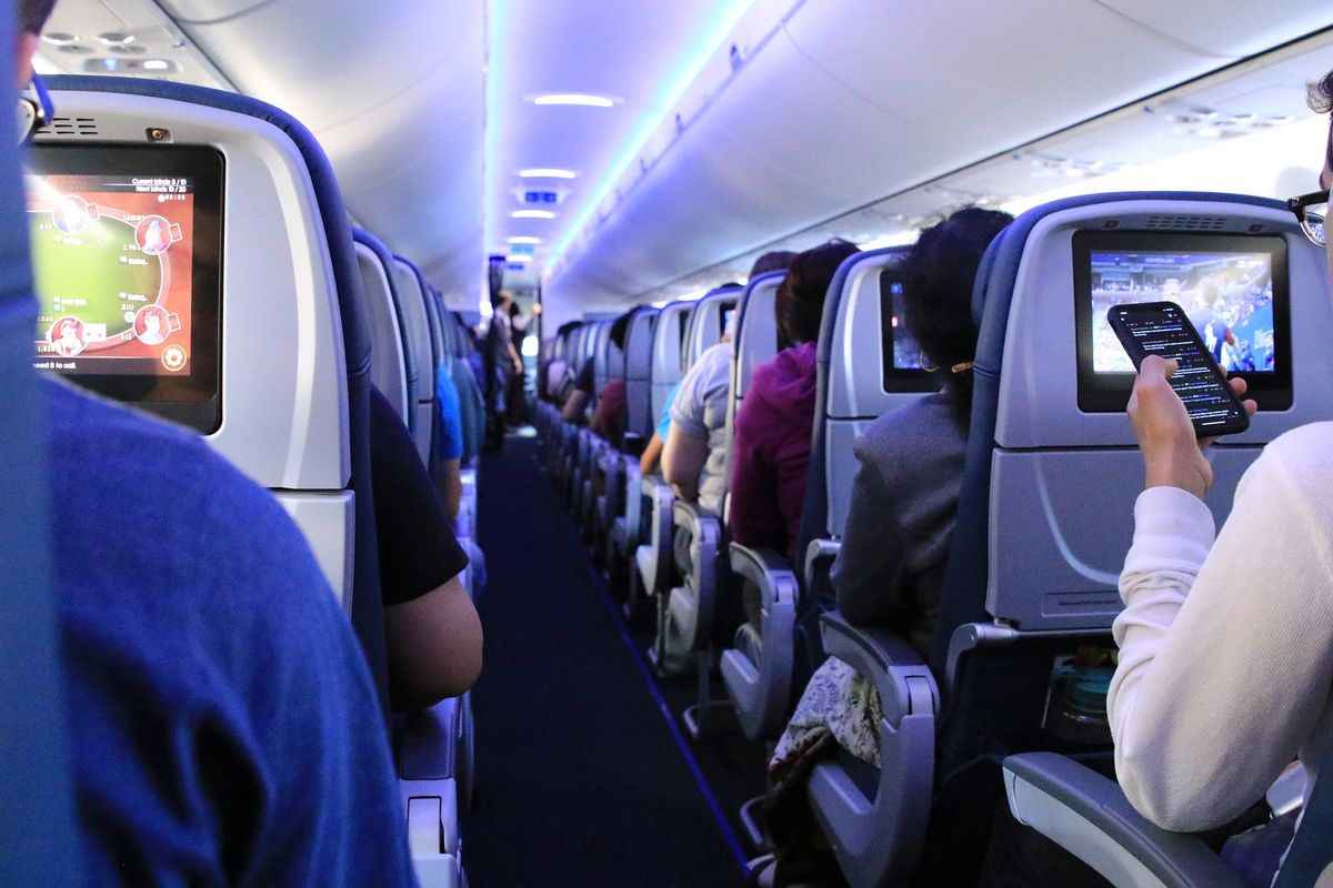 Aisle view of passengers on airplane during a flight
