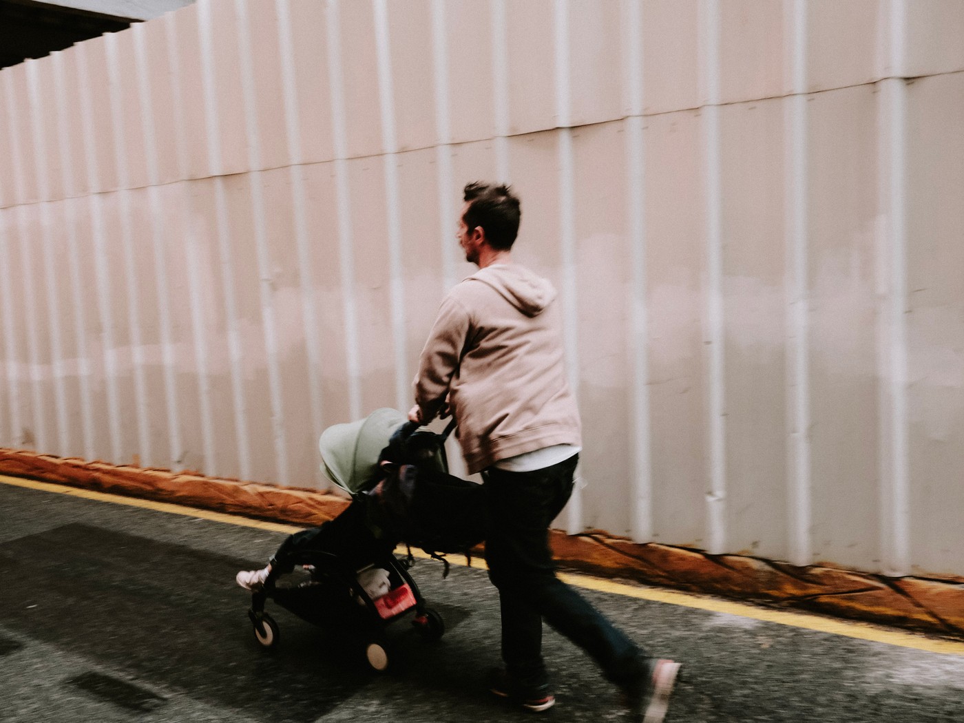 Parent folding a stroller at the aircraft door before boarding with a baby