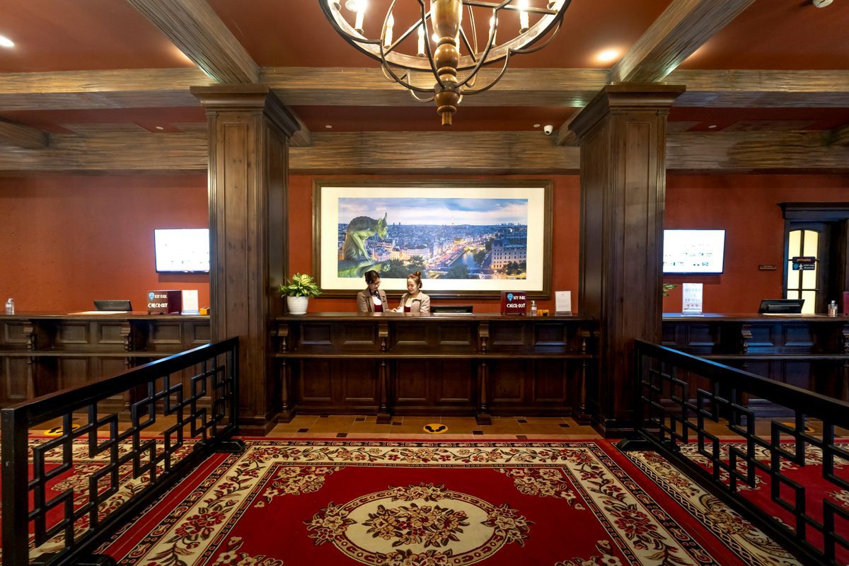 Elegant hotel lobby with reception desk. Two women stand behind the counter. 