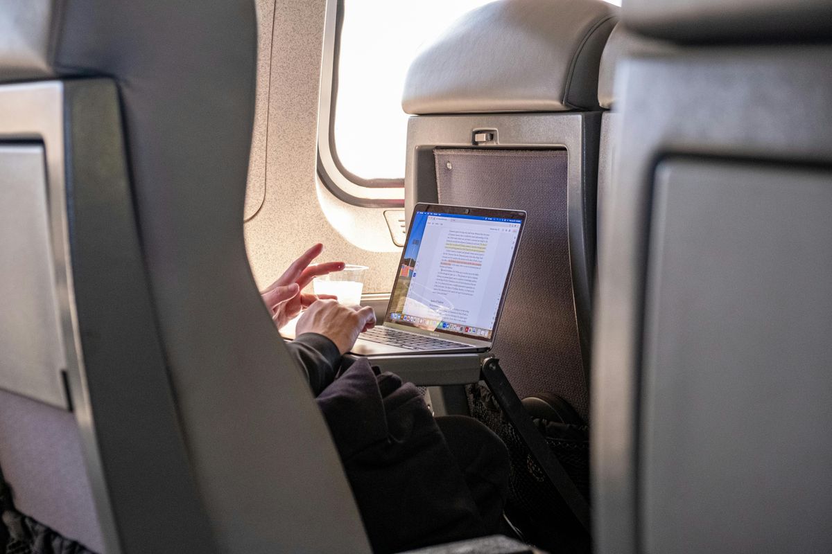 Someone working on a laptop on the plane