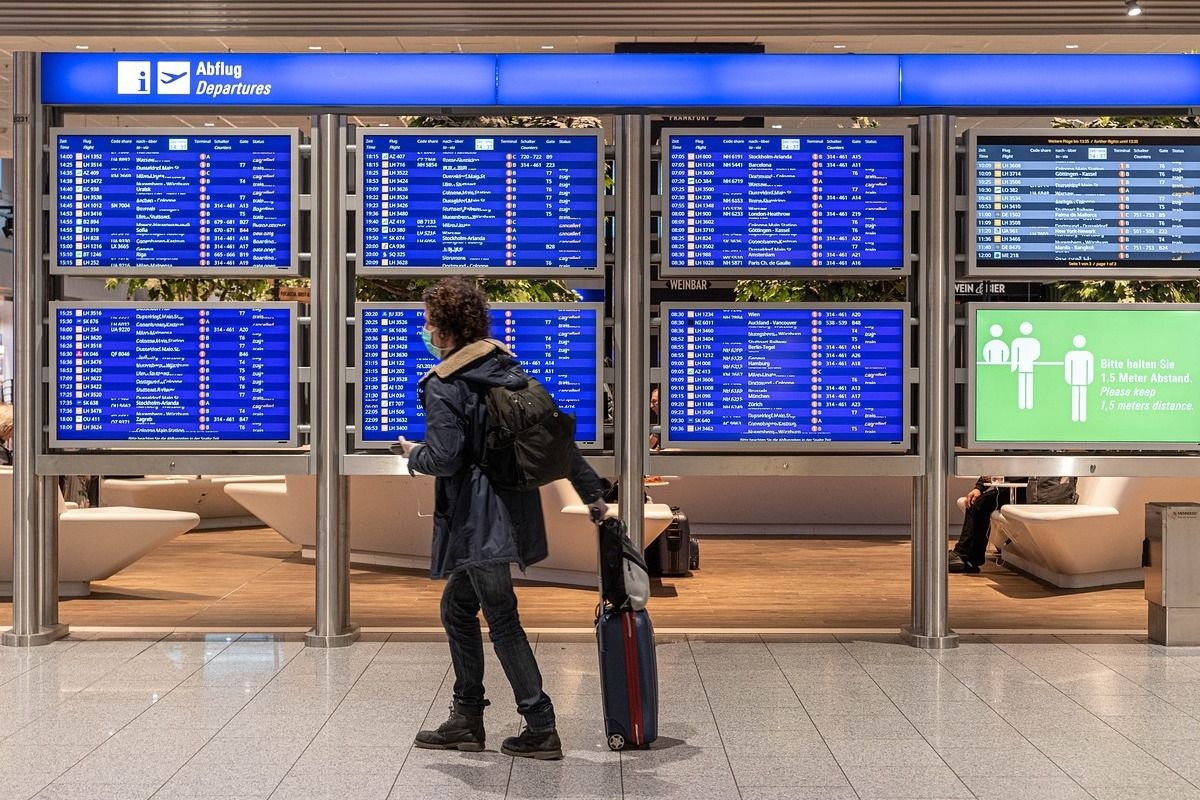 Man with mask at airport getting ready for summer travel