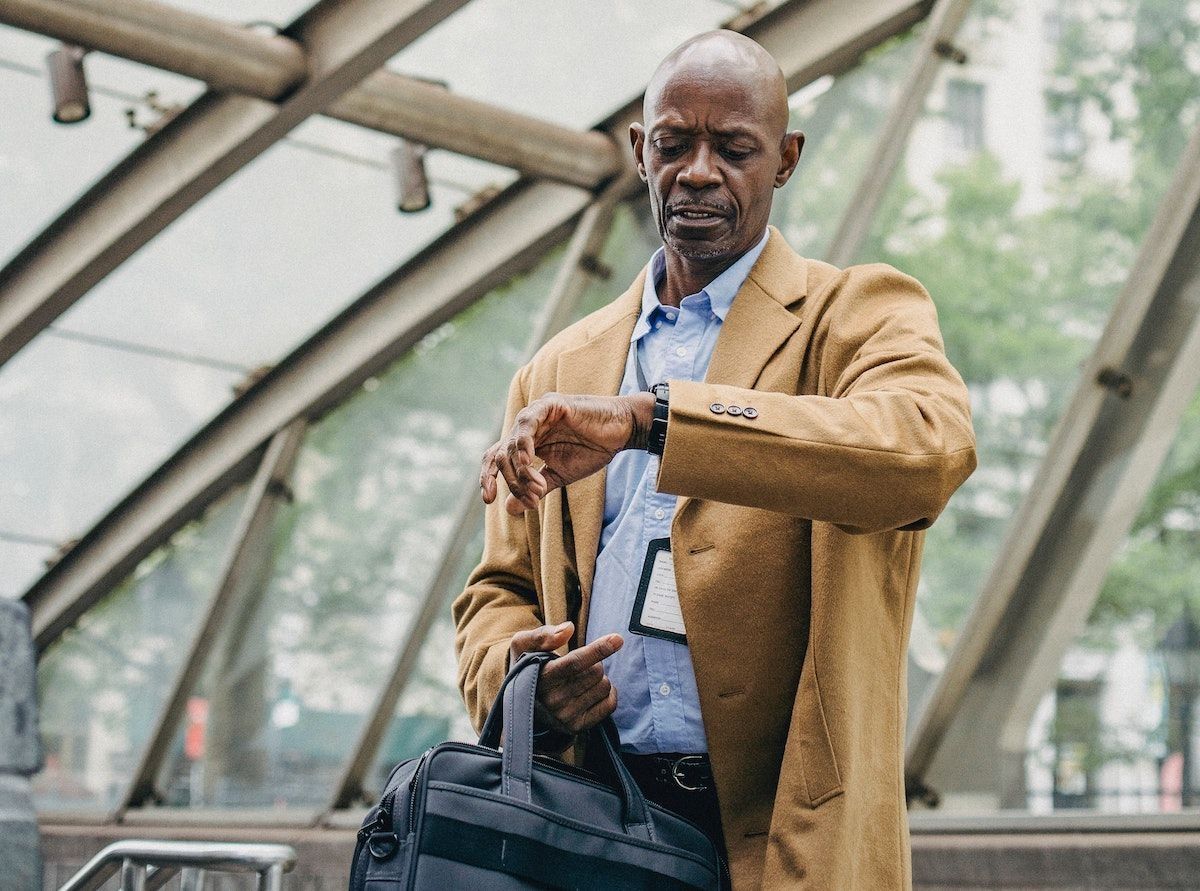 Bărbat care își verifică ceasul după întârzierea zborului