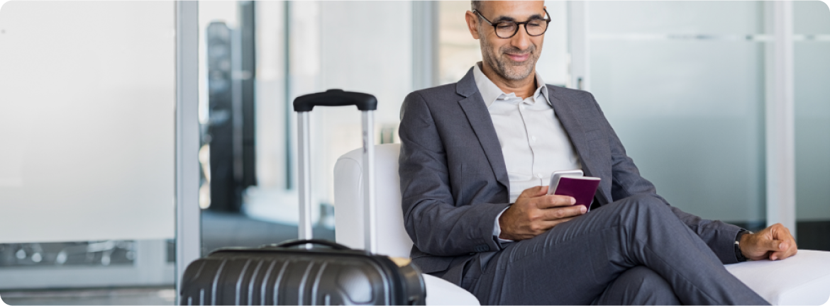 A man at the airport is looking at the phone