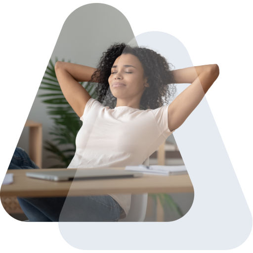 Woman sitting at her desk with a happy, relaxed posture and her eyes closed