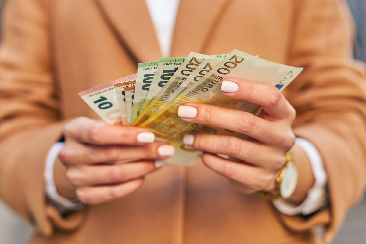 Hands holding Euro currency, representing successful affiliate payouts or flight compensation.