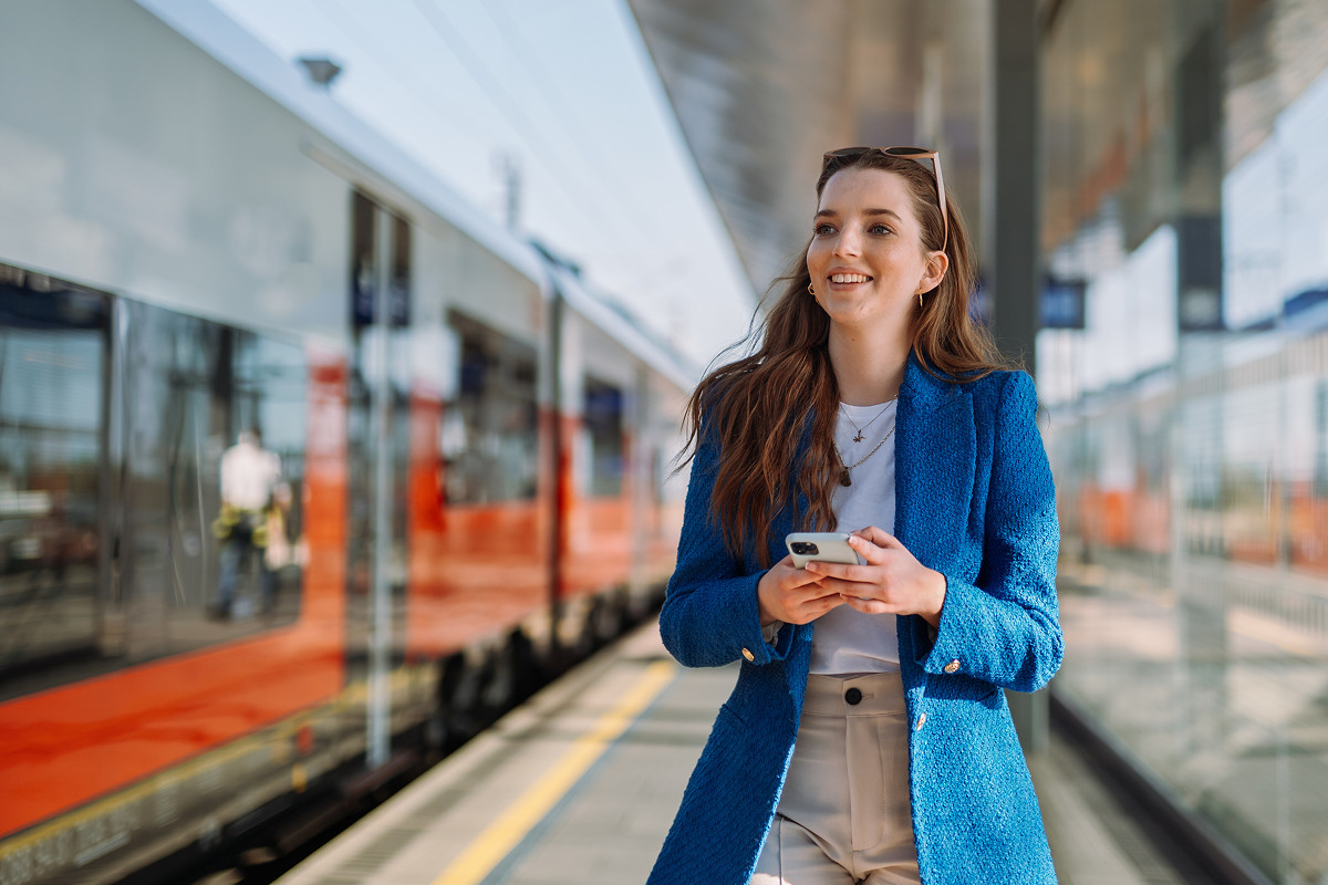 Woman checking train delay status and compensation rights on a smartphone